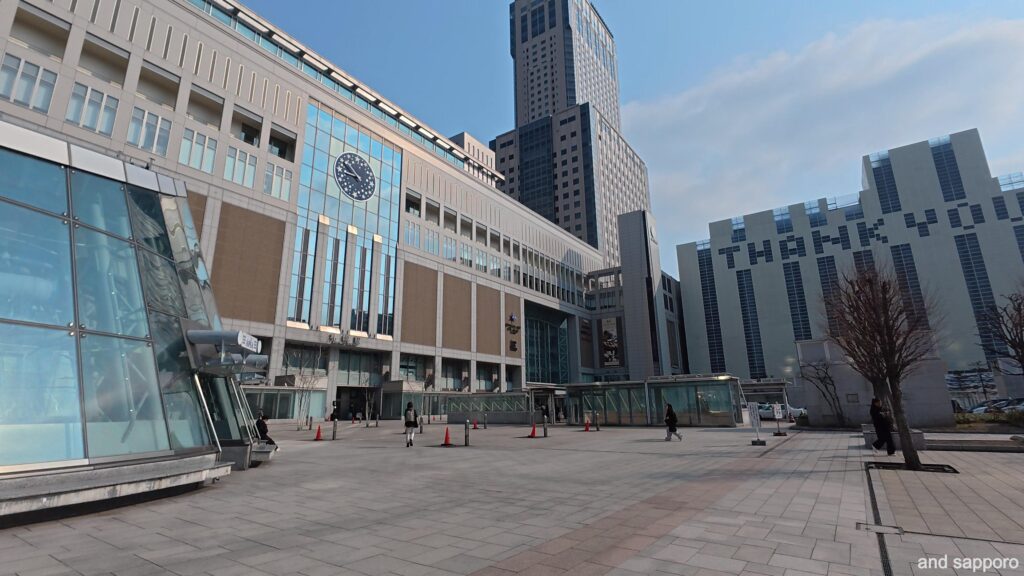 人がまばらな早朝の札幌駅南口広場。広々とした石畳に建物の長い影が伸び、都会の静かな夜明けを感じさせるゴールの風景。