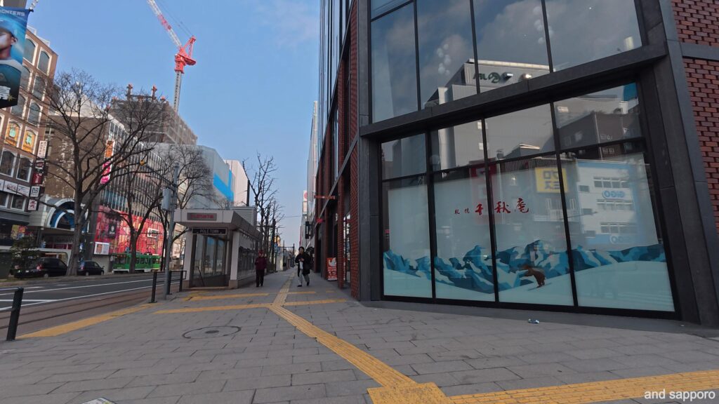 札幌・駅前通に面した千秋庵本店。モダンなホテルの1階にあり、落ち着いたレンガ調の壁面と大きなガラス張りの入り口が特徴。