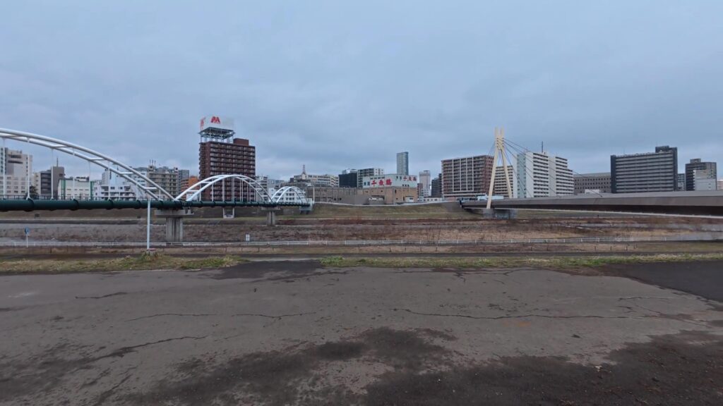 札幌市街地を流れる豊平川。川の先は都心のビルが立ち並ぶ風景。
