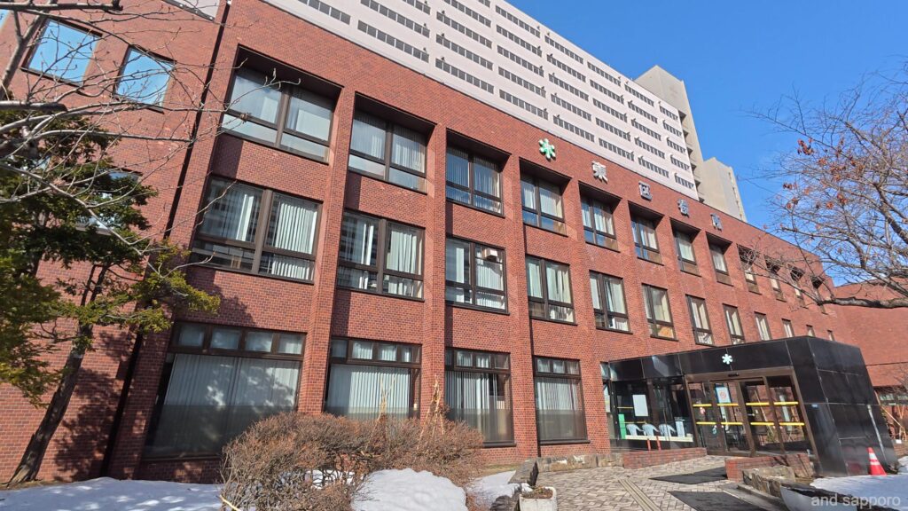 札幌市東区役所の外観。青空の下に佇む庁舎の風景。