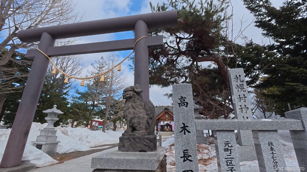 札幌村神社の鳥居と社殿。木々に囲まれた歴史を感じる境内の様子。