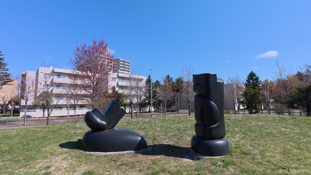 ひばりが丘西公園の緑地内に佇む大正時代の石造りサイロと、手前に設置されたモニュメント「バブル・ブーン」